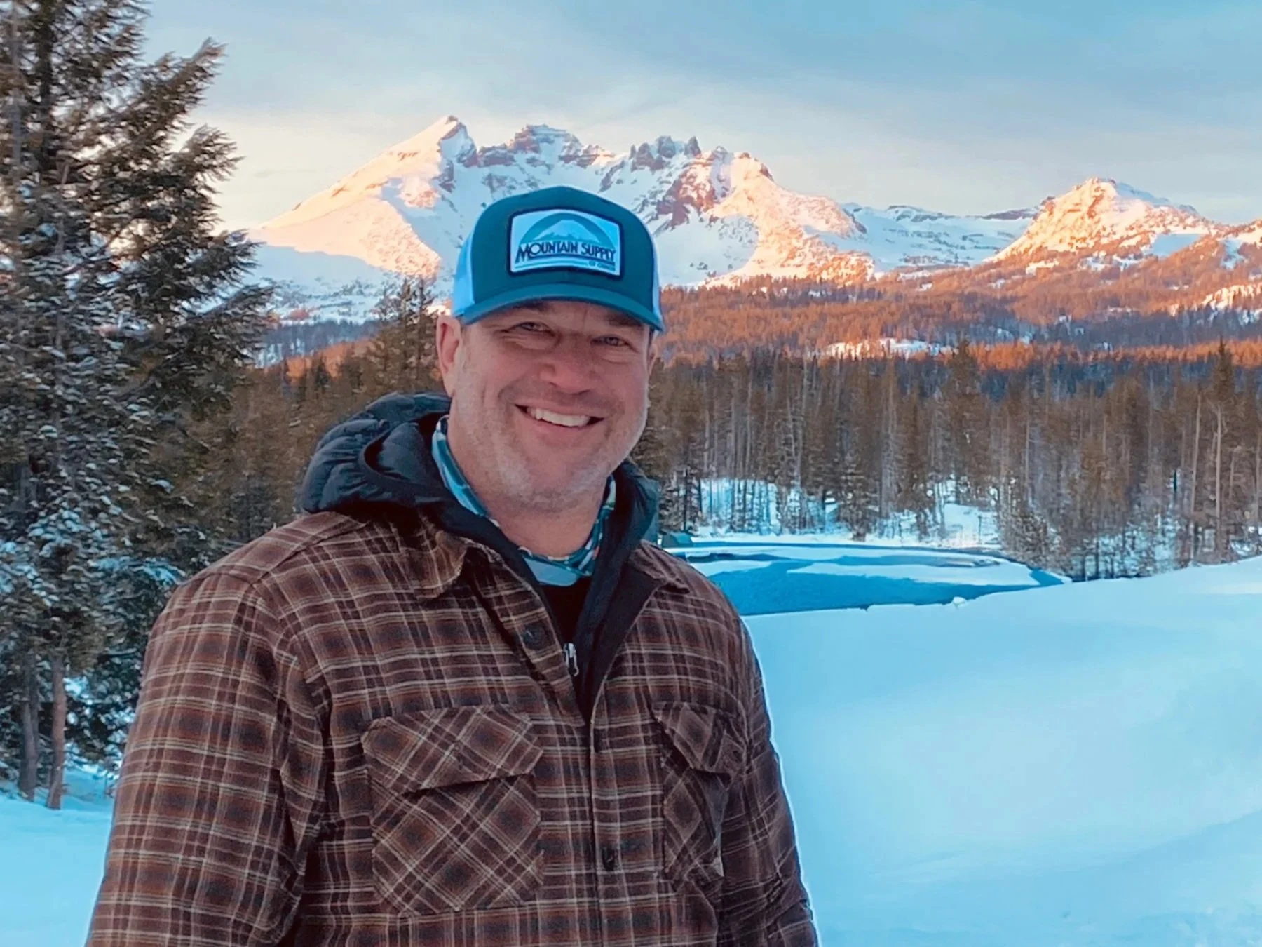 Casey O’Brien outdoors beside a snowy mountain lake